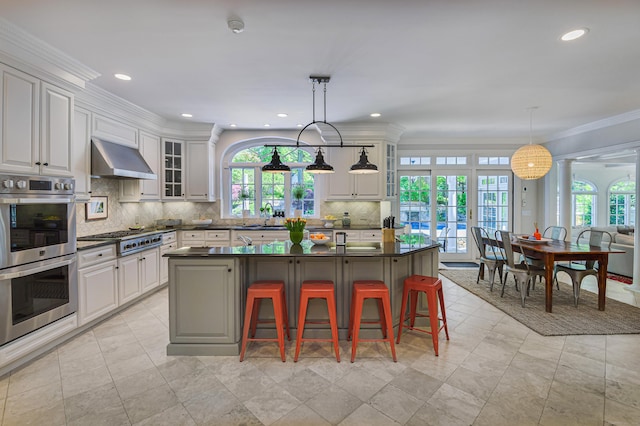 134 Nod Rd, Ridgefield, CT 06877 - kitchen featuring appliances with stainless steel finishes, under cabinet range hood, dark countertops, a sink, and tasteful backsplash