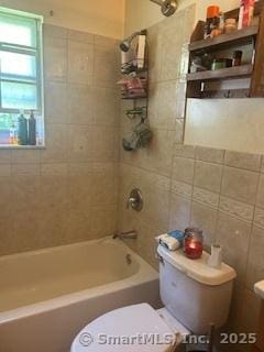 full bath featuring toilet, tile walls, and shower combination