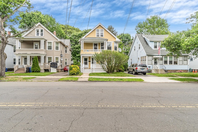 441 Savin Ave, West Haven, CT 06516 - view of front facade featuring covered porch, a balcony, a residential view, and concrete driveway