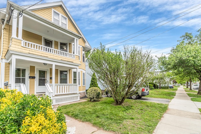 441 Savin Ave, West Haven, CT 06516 - view of property exterior featuring a balcony, a porch, and a lawn