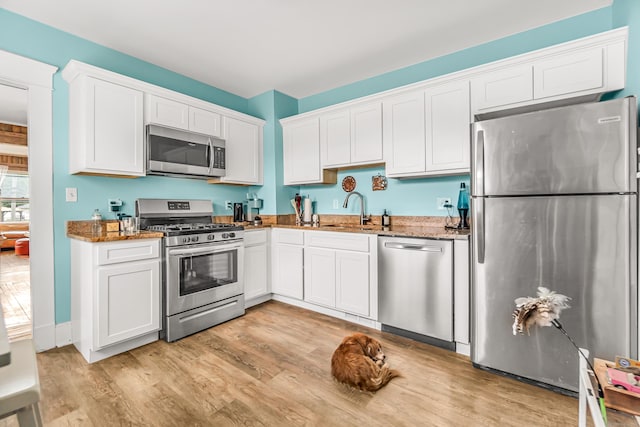 441 Savin Ave, West Haven, CT 06516 - kitchen featuring stainless steel appliances, a sink, dark stone counters, and white cabinetry