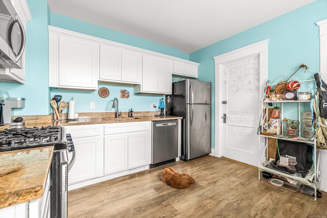 441 Savin Ave, West Haven, CT 06516 - kitchen with appliances with stainless steel finishes, a sink, light wood-style floors, and white cabinetry