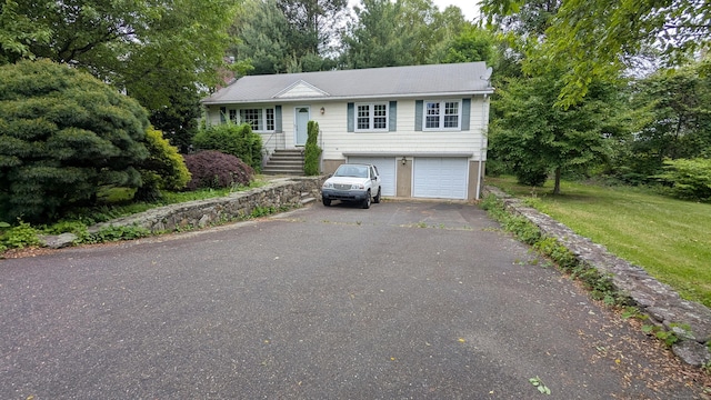 11 Twin Brooks Ln, Fairfield, CT 06824 - view of front facade with driveway, an attached garage, view of scattered trees, and a front lawn