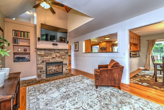 76 Crestwood Rd, Bethany, CT 06524 - living room with ceiling fan, a fireplace, wood finished floors, baseboards, and a wainscoted wall