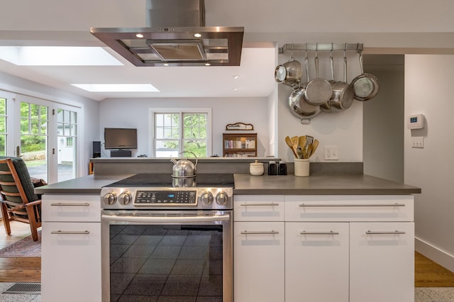 24 River Rd, Deep River, CT 06417 - kitchen featuring stainless steel electric stove, exhaust hood, a skylight, open floor plan, and white cabinetry