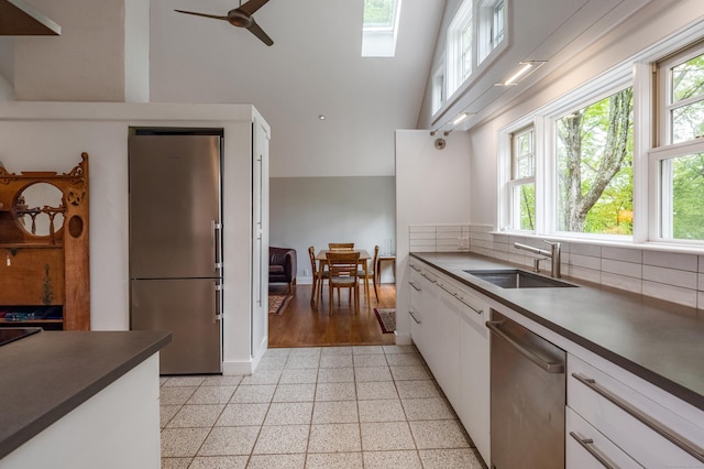 24 River Rd, Deep River, CT 06417 - kitchen with stainless steel appliances, a sink, dark countertops, healthy amount of natural light, and a high ceiling