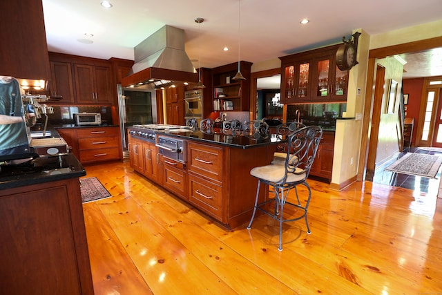 289 Woodchuck Ln, Harwinton, CT 06791 - kitchen featuring island range hood, dark countertops, a center island, a warming drawer, and light wood-style floors