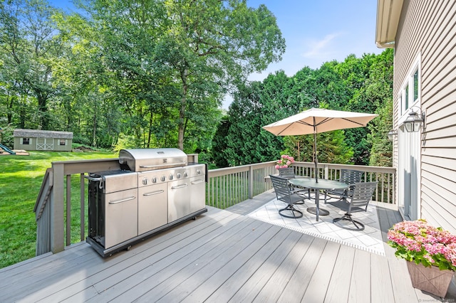 67 Old Farms Rd, Glastonbury, CT 06073 - wooden deck featuring outdoor dining space, a lawn, view of wooded area, and a storage shed