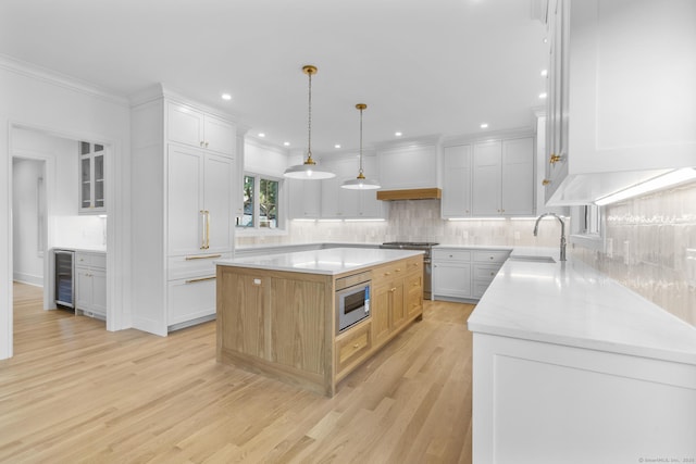45 Robin Cir, Fairfield, CT 06824 - kitchen featuring stainless steel appliances, a sink, beverage cooler, light wood-style floors, and decorative backsplash
