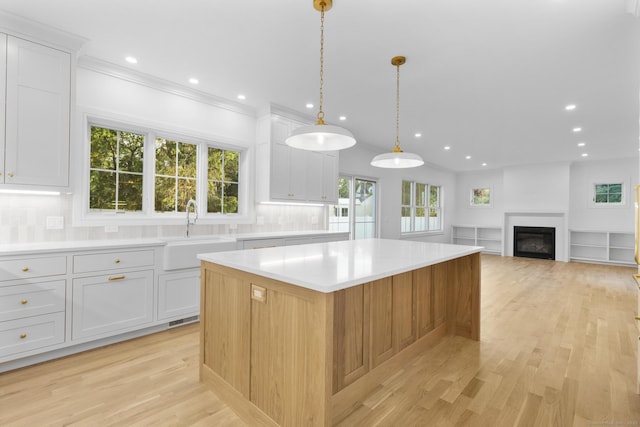 45 Robin Cir, Fairfield, CT 06824 - kitchen featuring a sink, a center island, light countertops, decorative backsplash, and healthy amount of natural light