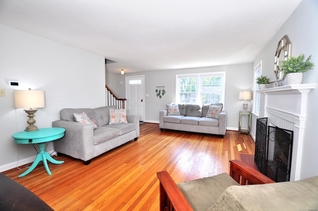 6 Lennox Ave, Windsor, CT 06095 - living area with wood finished floors, a brick fireplace, and stairs