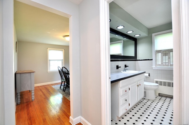 6 Lennox Ave, Windsor, CT 06095 - bathroom featuring radiator heating unit, vanity, tile walls, and wood finished floors