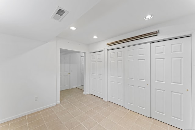 56 Pembroke Rd Apt 11, Danbury, CT 06811 - unfurnished bedroom with baseboards, recessed lighting, light tile patterned floors, and multiple closets