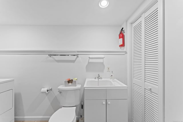 56 Pembroke Rd Apt 11, Danbury, CT 06811 - bathroom featuring a closet, vanity, toilet, washer / clothes dryer, and baseboards