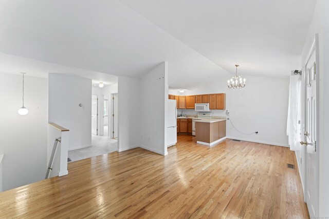 56 Pembroke Rd Apt 11, Danbury, CT 06811 - unfurnished living room with lofted ceiling, light wood-style flooring, a chandelier, and baseboards