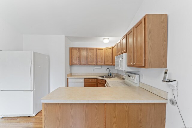 56 Pembroke Rd Apt 11, Danbury, CT 06811 - kitchen with white appliances, a sink, a peninsula, and light countertops