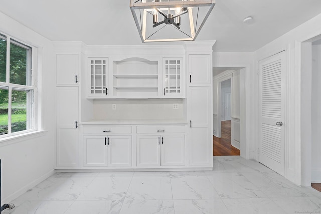 2921 Nichols Ave, Trumbull, CT 06611 - kitchen featuring a chandelier, light marble finish floors, white cabinets, open shelves, and baseboards