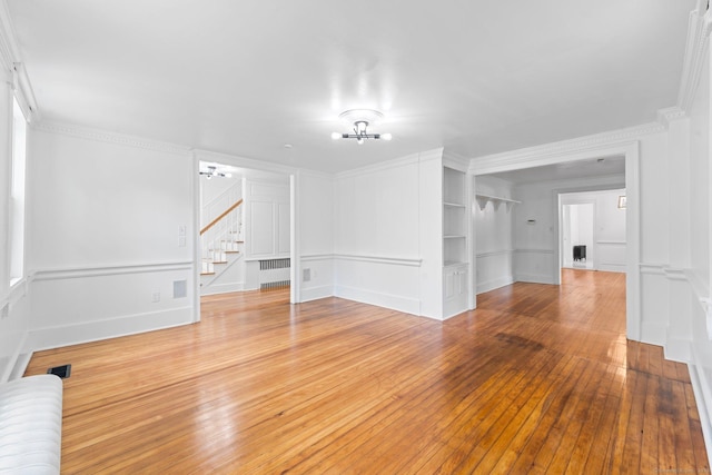 2921 Nichols Ave, Trumbull, CT 06611 - spare room featuring a decorative wall, stairway, radiator, wood-type flooring, and crown molding