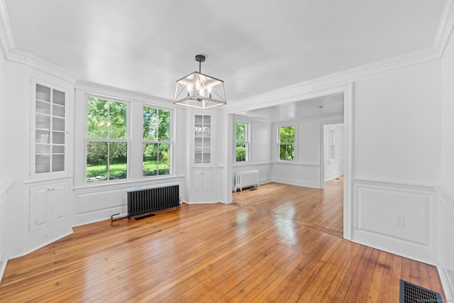 2921 Nichols Ave, Trumbull, CT 06611 - unfurnished dining area featuring radiator, a chandelier, ornamental molding, and light wood-style floors