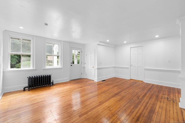 2921 Nichols Ave, Trumbull, CT 06611 - unfurnished living room featuring radiator heating unit, wood-type flooring, recessed lighting, ornamental molding, and baseboards