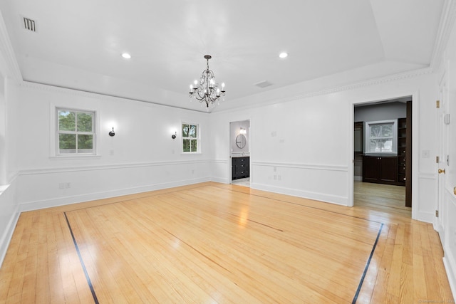 2921 Nichols Ave, Trumbull, CT 06611 - unfurnished living room with a chandelier, a raised ceiling, plenty of natural light, light wood-style floors, and ornamental molding