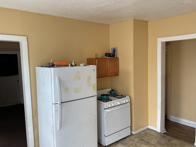 74 Branch St, Waterbury, CT 06704 - kitchen featuring white appliances, brown cabinetry, and baseboards