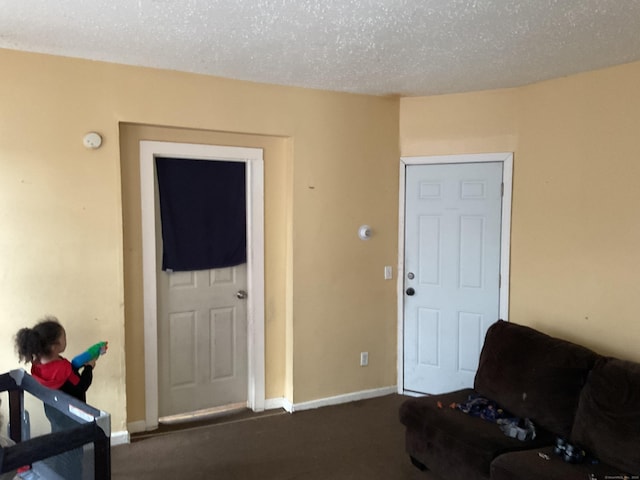 74 Branch St, Waterbury, CT 06704 - living area featuring dark colored carpet, baseboards, and a textured ceiling