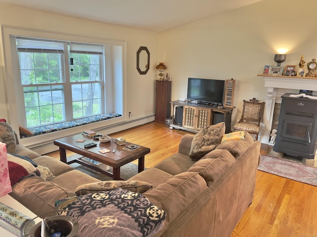 living room featuring light wood-style flooring, a wood stove, and a baseboard radiator
