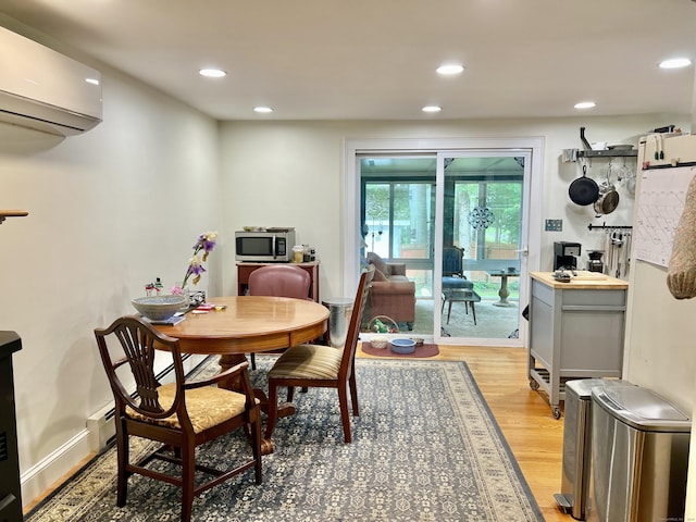 dining space featuring a wall unit AC, light wood-style floors, and recessed lighting