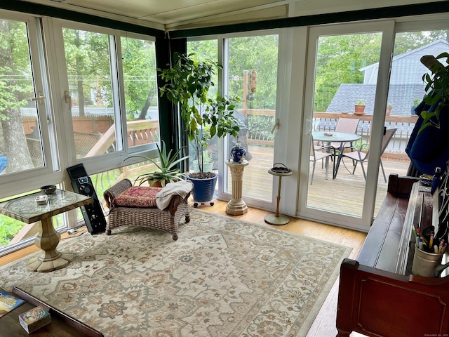 sunroom with plenty of natural light and wood finished floors
