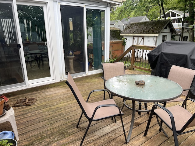 deck with outdoor dining space and area for grilling