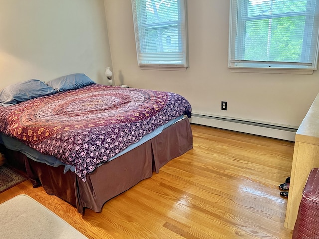 bedroom featuring a baseboard radiator and light wood-style flooring