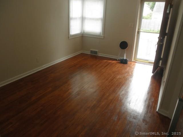 40 Wake St, Bridgeport, CT 06610 - empty room featuring dark wood-type flooring, plenty of natural light, and baseboards