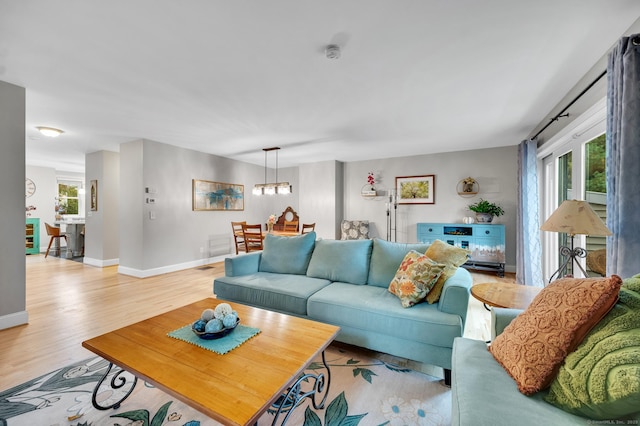 645 Prospect Ave Unit 11, West Hartford, CT 06105 - living area with light wood-type flooring, baseboards, and a chandelier
