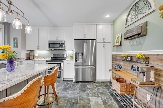645 Prospect Ave Unit 11, West Hartford, CT 06105 - kitchen with stainless steel appliances, white cabinets, backsplash, a kitchen bar, and recessed lighting