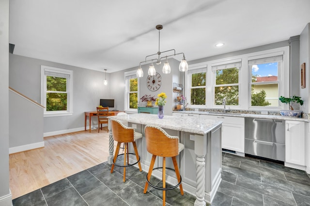 645 Prospect Ave Unit 11, West Hartford, CT 06105 - kitchen featuring stainless steel dishwasher, a sink, light stone counters, a kitchen island, and white cabinets