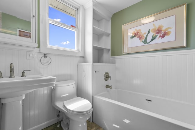 62 Surf Ave, Milford, CT 06460 - bathroom with toilet, a bathtub, wainscoting, and wooden walls