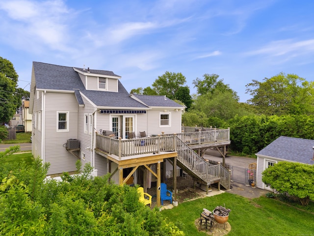 62 Surf Ave, Milford, CT 06460 - rear view of house with an outdoor fire pit, a wooden deck, a yard, a shingled roof, and stairs