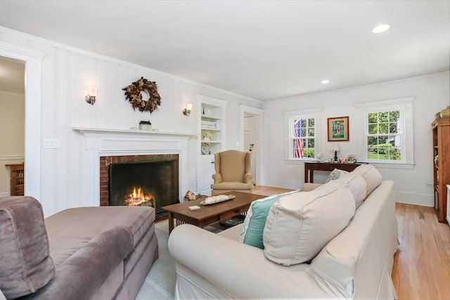 11 Overlook Rd, Westport, CT 06880 - living area with a brick fireplace, light wood finished floors, crown molding, built in features, and recessed lighting