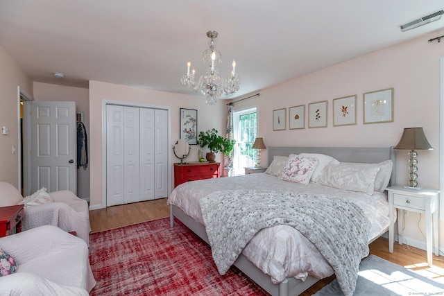23 Anita Way, Warren, CT 06754 - bedroom with a chandelier, wood finished floors, a closet, and baseboards