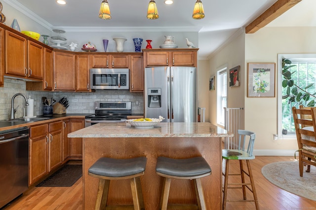 23 Anita Way, Warren, CT 06754 - kitchen featuring stainless steel appliances, a sink, light wood-style flooring, brown cabinetry, and a center island