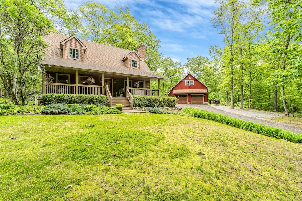 407 Starkweather Rd, Plainfield, CT 06374 - view of front of house featuring an outbuilding, a chimney, a porch, a garage, and a front lawn