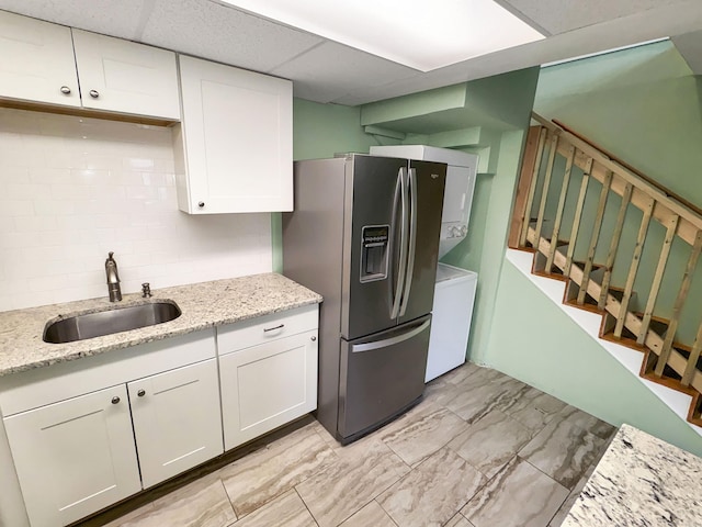 330 Short Beach Rd Apt F6, East Haven, CT 06512 - kitchen with stainless steel fridge with ice dispenser, a sink, white cabinets, stacked washer and clothes dryer, and light stone counters