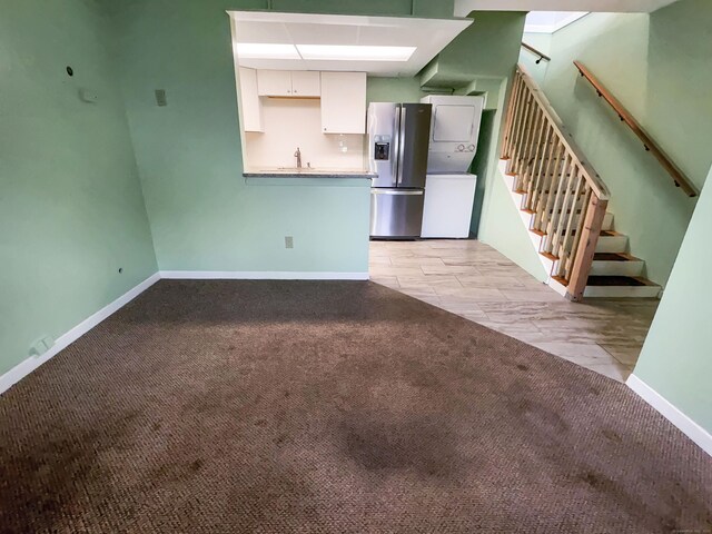 330 Short Beach Rd Apt F6, East Haven, CT 06512 - unfurnished living room with stacked washer / drying machine, light colored carpet, stairs, a sink, and baseboards