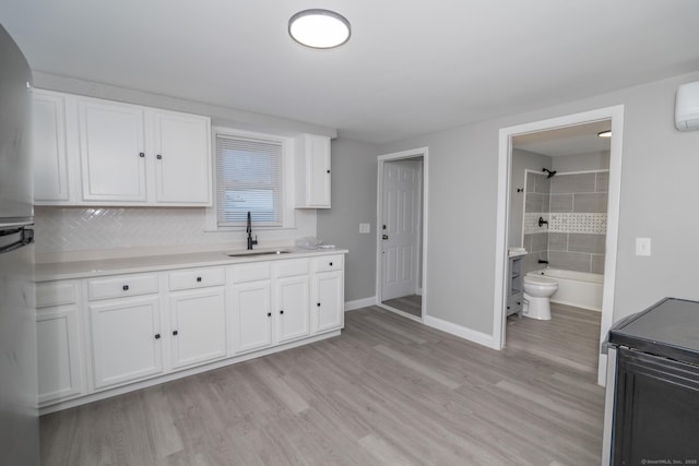 670 Putnam Pike, Rhode Island, RI 02828 - kitchen with a sink, white cabinetry, baseboards, light wood-style floors, and light countertops
