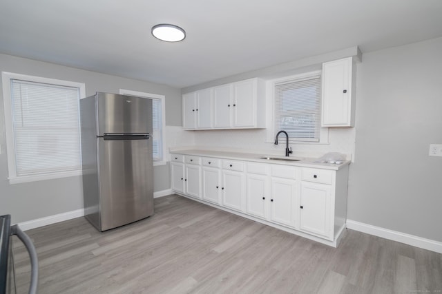 670 Putnam Pike, Rhode Island, RI 02828 - kitchen featuring freestanding refrigerator, a sink, light wood-type flooring, and white cabinetry