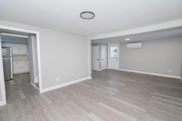 670 Putnam Pike, Rhode Island, RI 02828 - empty room with an AC wall unit, light wood-type flooring, and baseboards