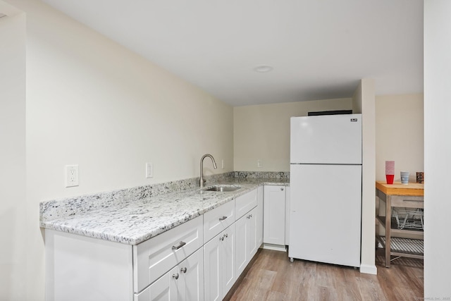 27 E Gate Rd, Danbury, CT 06811 - kitchen with freestanding refrigerator, a sink, light wood-style floors, and white cabinets