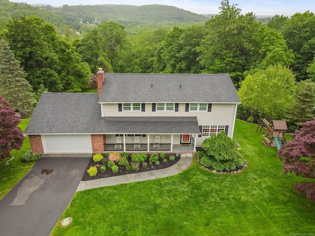 27 E Gate Rd, Danbury, CT 06811 - view of front of house with covered porch, asphalt driveway, a chimney, a front yard, and a view of trees