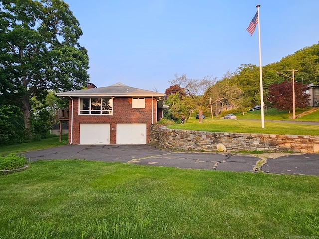 36 View St, Plainville, CT 06062 - view of side of home with asphalt driveway, an attached garage, a yard, brick siding, and a chimney
